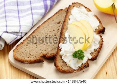 Bread with lard and apple slices on wooden board