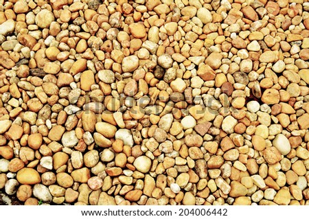 Gravel path. Smooth round pebbles from riverbed spread on the driveway. Smooth stone background.