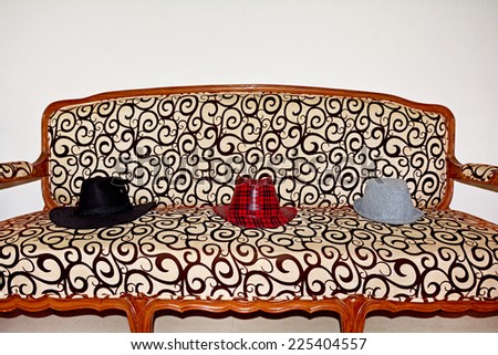 Red checkered, black and grey hats on sofa. The good, the bad and the ugly!