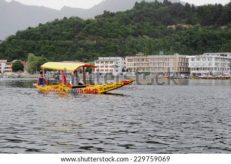 DAL LAKE, SRINAGAR, KASHMIR, INDIA, MAY 06, 2012: A houseboat bearing the curious name \'Photo shop\' being rowed by two Kashmiri youth. They make money by taking photos of tourists in the boats.
