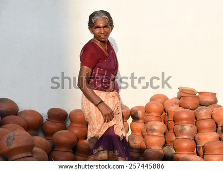TRIVANDRUM, KERALA, INDIA, MARCH 03, 2015: Woman Entrepreneur. Woman empowerment. Woman power. Bread winner. A proud lady sells pots during Attukal ponkala festival in the Thiruvananthapuram city.