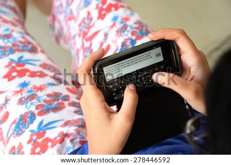 The new generation is addicted to technology. Traditional letters and cards are redundant in the age of internet and cell phones. An Indian teenage girl is sending message on her mobile phone.
