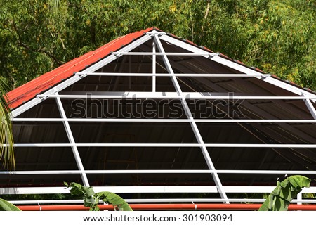 Unfinished erection of aluminium roof on the terrace of a house in Trivandrum. Geometric lines, shapes and patterns. Truss work.