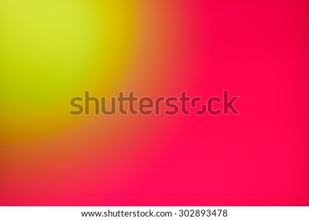 Abstract yellow blur against shiny bright red background. Yellow sun in the corner of red sky. An out of focus yellow ball against a red wall.
