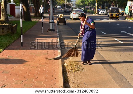 TRIVANDRUM, KERALA, INDIA, AUGUST 31, 2015: Swachh Bharat Abhiyan. A woman sweeping the city road in the morning manually with a traditional broom.