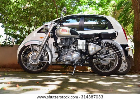 TRIVANDRUM, KERALA, INDIA, AUGUST 29, 2015: Big bike, small car. Royal Enfield bike parked by the side of Tata\'s small car Nano Twist.