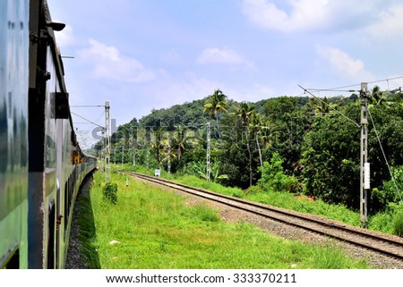 PIRAVAM, KERALA, INDIA, OCTOBER 22, 2015: Indian Railways. World\'s longest railway system. View from the door of the train on a bright day showing another track and the side of the train.