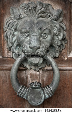 Lion head door knocker, made of cast iron but tarnished by the years. A traditional design, also widely known as the Downing Street door knocker.