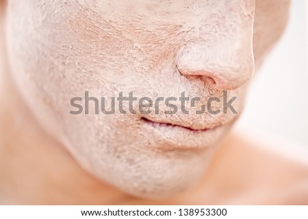 A close-up of a young male model's face with foundation applied to it.