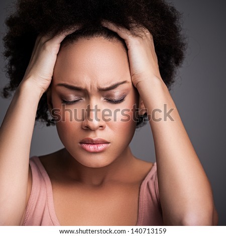 Young African Woman Suffering From A Terrible Headache.