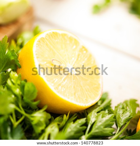 Fresh lemon half on parsley leaves.