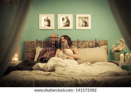 Married couple drinking champagne before their first wedding night.