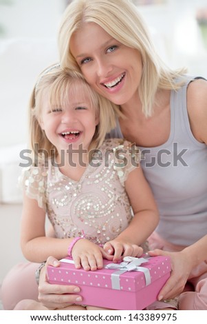 A mother and her daughter sharing happy moments together for the girl\'s birthday.