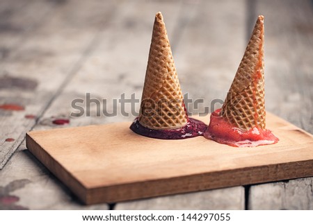 Two cones with fruit sorbet turned upside down.