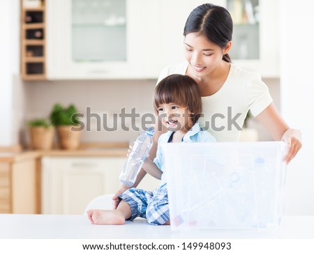 A caring mother teaching her child about the importance of recycling.