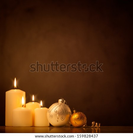 A set of white candles and Christmas ornaments reflecting the tranquility and holiness of winter holidays.