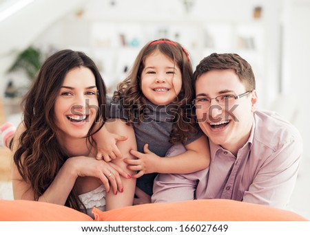 Smiling mother , father and daughter in their living room.