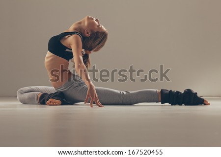 Young woman doing yoga exercises indoors.