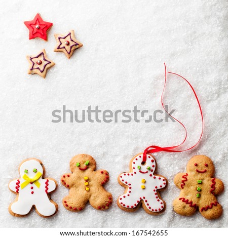 Gingerbread men and star-shaped gingerbread cookies on snow.
