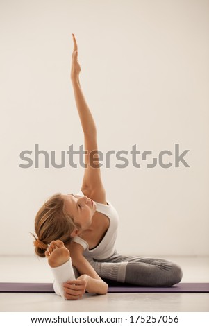 Indoor shot of a young gymnast doing stretching exercises.