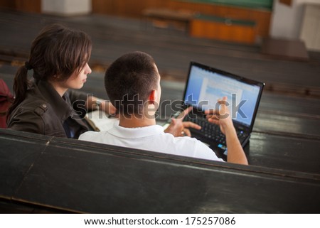 Two college students studying together at the lecture hall.