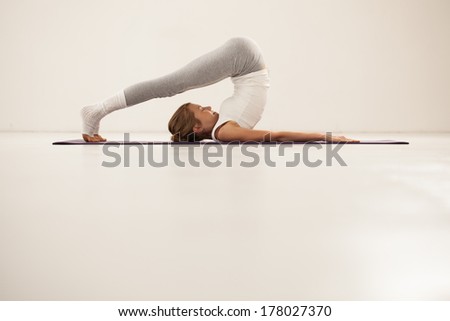 Indoor shot of a young woman doing yoga.