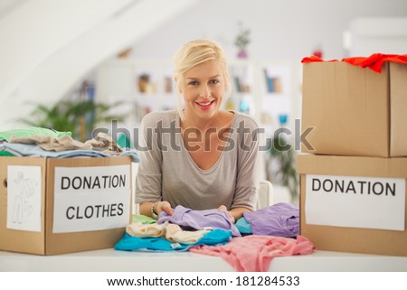Woman preparing the old clothes she wants to donate for charity.