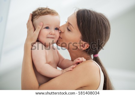 Young mother kissing her adorable baby boy.