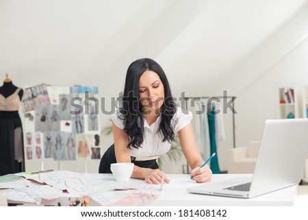 Fashion designer making sketches at her office.