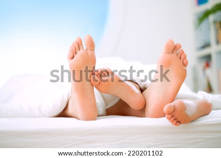 Close-up of the feet of a couple sleeping together.