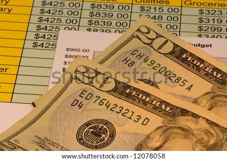 Close up of two american twenty dollar bills along with chart showing budget