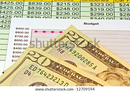 Close up of two american twenty dollar bills along with a chart for personal budget