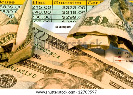 Close up of american twenty dollar bills along with a budget chart