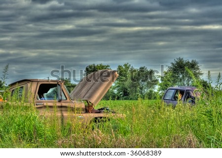 Old wrecked vehicles abandoned in field done in HDR