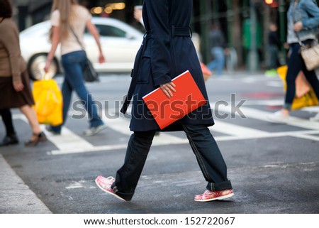 Girl walking on the street and holding red book.