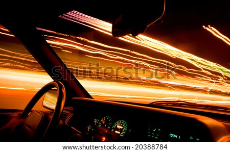 Car light trails from front window, city in the night.