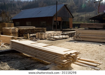 Lumber mill with wood storage, visible bright plank.