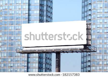 Big white billboard, between two blue sky scrapers.