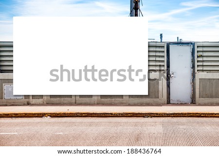 White billboard on the wall. Metal door on the right.