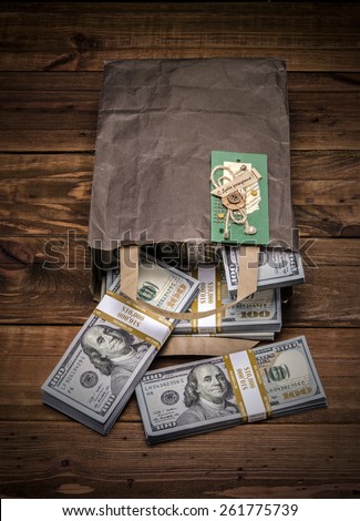 Brown paper bag containing that moolah and Congratulation card. Bag full of money - vintage photography of brown paper bag with stacks of hundred dollar bills on wooden background