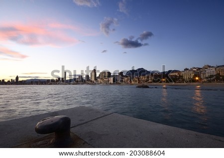 Mediterranean city Benidorm, with a mooring harbor and the Mediterranean sea in the foreground and the beaches and skyscrapers background.