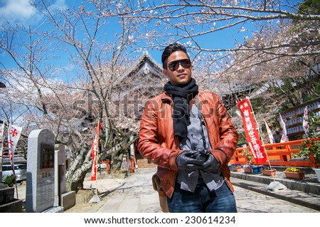 Thai black-skin man with sun glasses and camera traveling in japan