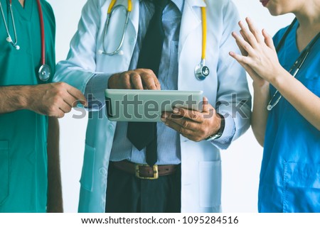Group of happy doctor surgeon and nurse with tablet in meeting on white background, Healthcare and medical concept