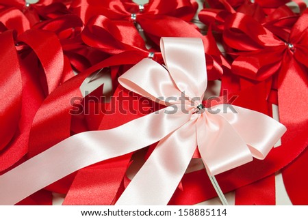pink ribbon bow on red ribbons background