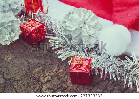 Christmas decoration with red Claus hats, silver ornament, gift box on wooden background