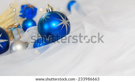 Christmas decoration with blue and silver ball, on white fabric background