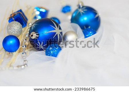 Christmas decoration with blue and silver ball, on white fabric background