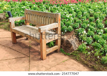 Wooden bench in flowers garden