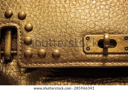 Closeup lock on woman leather bag, gold color