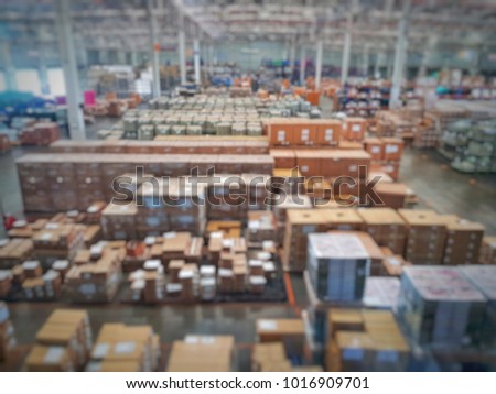 Blurred warehouse interior environment with full of catton boxes and pallets stacking in storage area in each location for inventory management and distribution